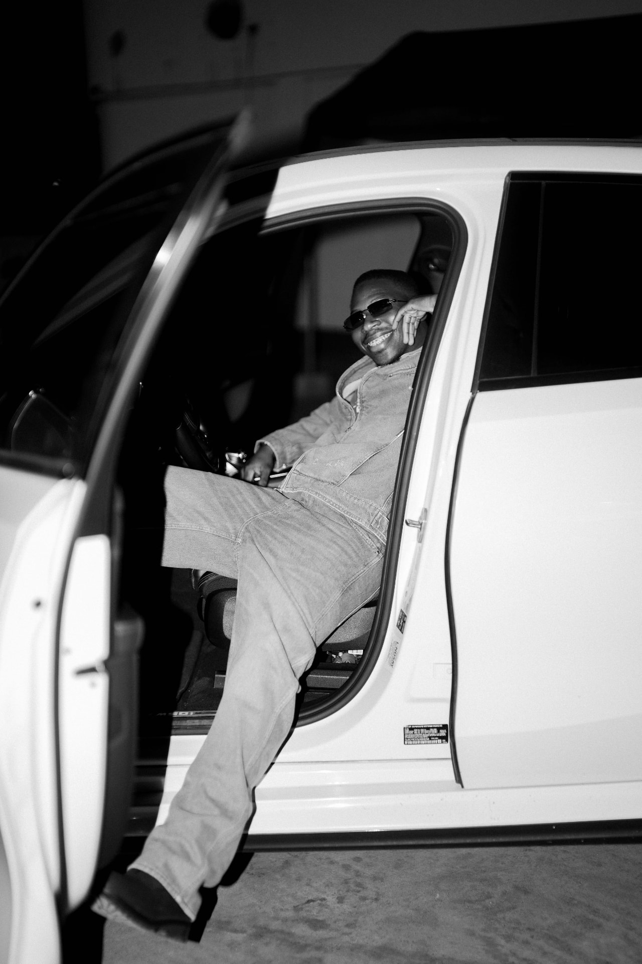LL Degree inside a vehicle in a black-and-white press photograph